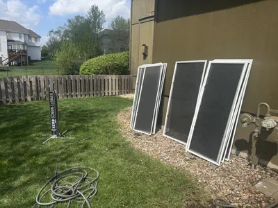 Window screen cleaning by Sparkle Window Cleaners — Window screens removed and lined up in yard for cleaning.