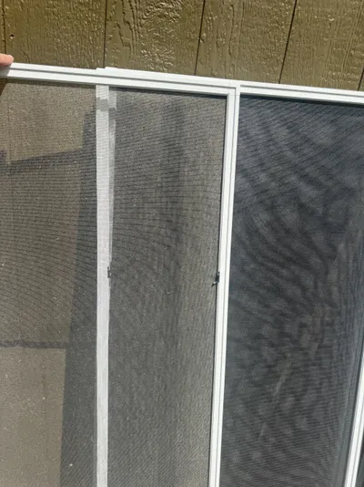 Window screen cleaning by Sparkle Window Cleaners — Clean window screen against siding